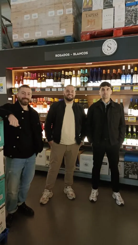 The STILLROOM team in front of the wine section at Makro Paseo Imperial, with pallets of boxes stacked above the displays