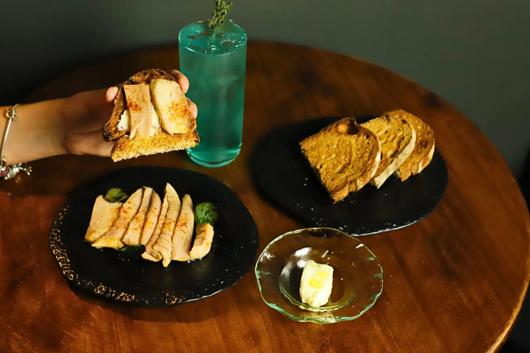 Preserves, toasts and a blue Stillroom cocktail on the venue's wooden table