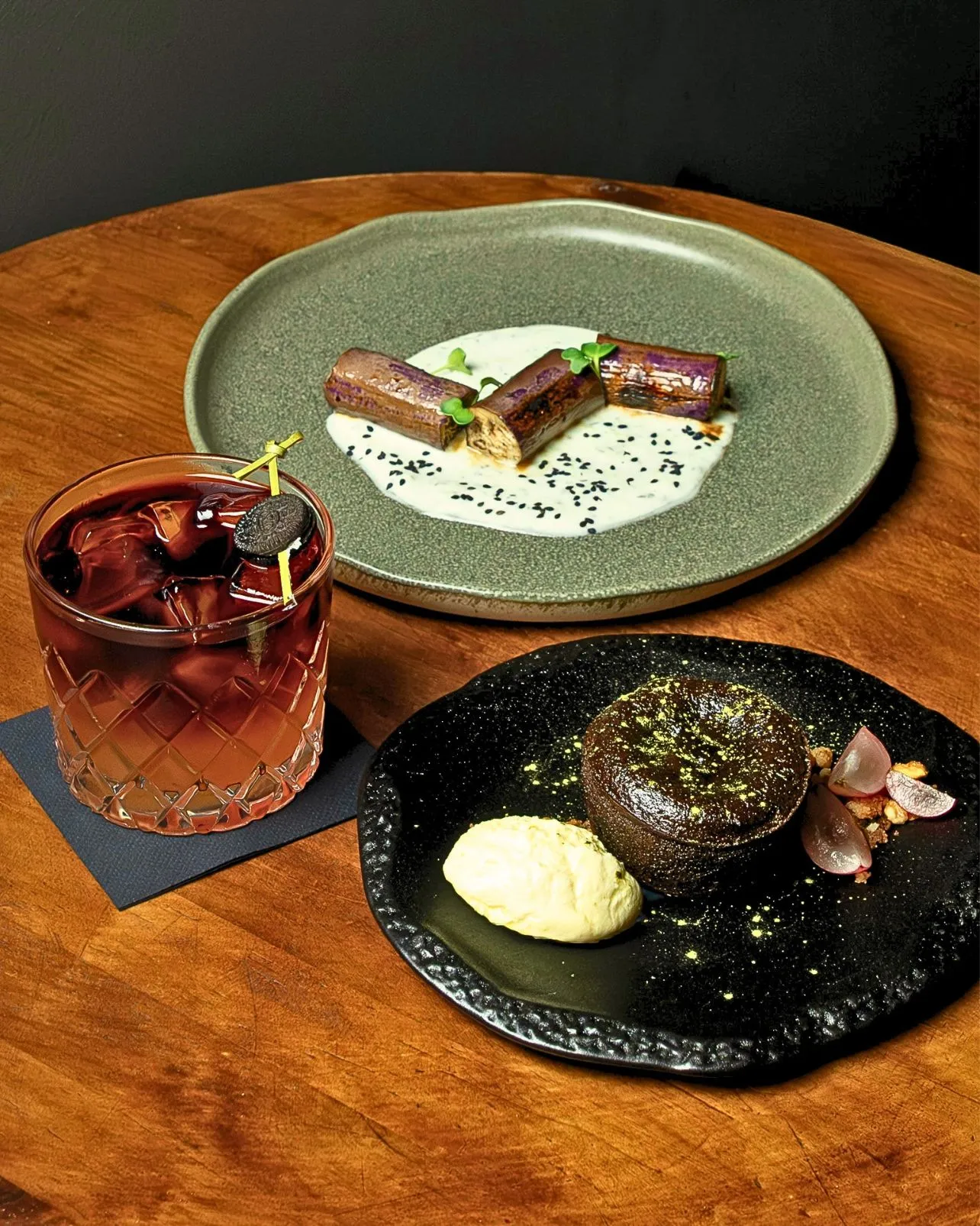 Bocados de Stillroom sobre madera: vermut con hielo, lomito de berenjena y coulant de chocolate