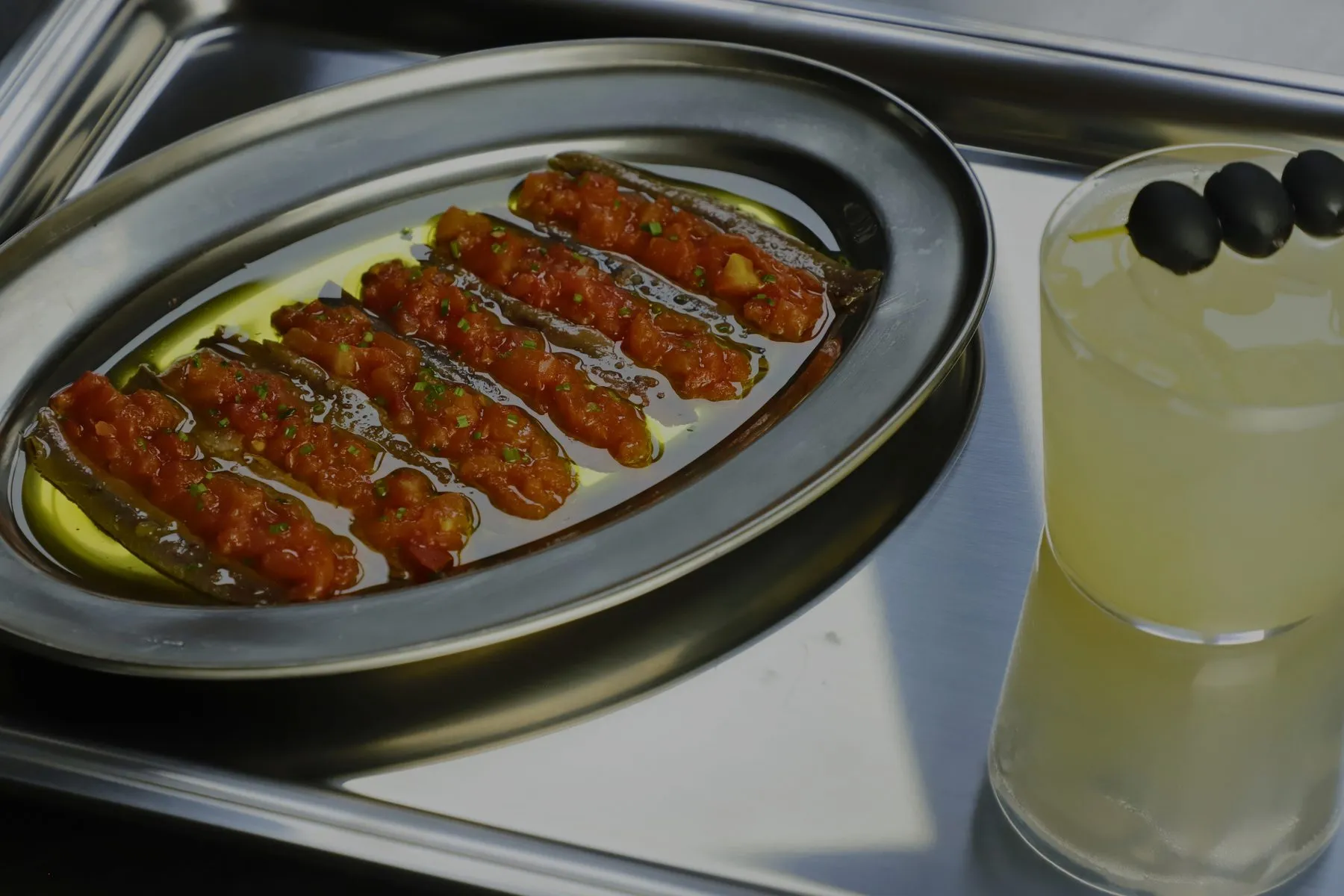 Anchoas con tomate y un aperitivo con aceitunas sobre la bandeja de Stillroom