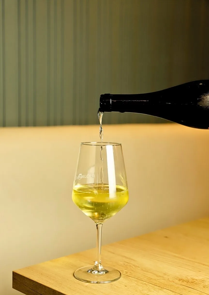 White wine being poured into a glass at the Stillroom table